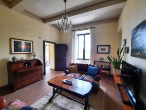 een woonkamer met een bank en een tafel bij Villa La Consuma : casa storica in paese, giardino, piscina, WiFi in San Giovanni dʼAsso