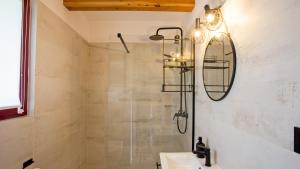 a bathroom with a shower and a sink and a mirror at Domek Pogodny Rowy Szachulcowa 4a in Rowy