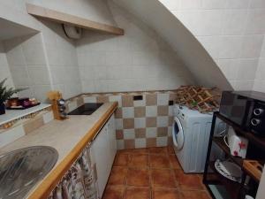 a kitchen with a sink and a washing machine at El rinconcito in Algodonales