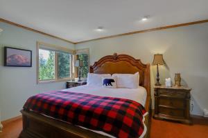 a bedroom with a bed with a plaid blanket at Bear Peak Lodge 1 Mile to Gondola and Great Views in Breckenridge