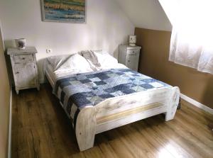 łóżko w pokoju z dwoma komodami i łóżko sidx sidx sidx sidx w obiekcie Domki Klara w Pobierowie