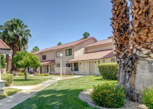 a house with a palm tree in a yard at \\Golf and Couples Oasis// Midcentury w/6 Pools Hot Tub in Palm Springs