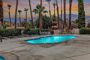 a swimming pool in a resort with palm trees at \\Golf and Couples Oasis// Midcentury w/6 Pools Hot Tub in Palm Springs