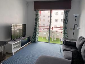 a living room with a couch and a flat screen tv at Apartamento de 3 hab en Costa Adeje centro in Adeje