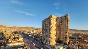 ein hohes gelbes Gebäude mitten in einer Stadt in der Unterkunft Departamento ejecutivo in Antofagasta