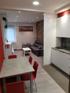 a kitchen and living room with a table and a couch at Apartamento en San Sebastián con patio exterior in Añorga-Lugariz