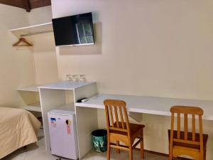 a room with a white desk and two chairs at Pousada In Garden in Teresópolis