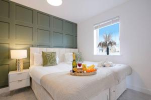 1 dormitorio con 2 camas, bandeja de fruta y ventana en Glebe House - 5 Bedroom 3.5 Bathroom - Sleeps 10 - Driveway Parking, Fast Wifi, SmartTVs with SkyTV, Xbox and Netflix by Yoko Property en Milton Keynes