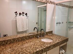 a bathroom with a sink and a shower at Pousada In Garden in Teresópolis