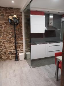 a kitchen with a lamp and a stone wall at Apartamento en San Sebastián con patio exterior in Añorga-Lugariz