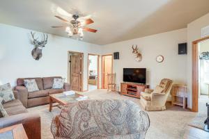 ein Wohnzimmer mit einem Sofa und einem TV in der Unterkunft Cozy Ski Cabin with Deck Near Taos Ski Valley! in San Cristobal