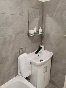 a bathroom with a sink and a toilet and a mirror at Newly Renovated Cosy 1 bed flat, 4 minutes walk to Town Centre, 3 minutes walk to the train station, Free parking, Modern, fresh and spacious living room, Netflix ready smart TV, Wifi in Wellingborough
