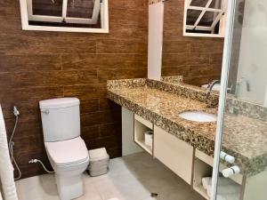 a bathroom with a toilet and a sink at Pousada In Garden in Teresópolis