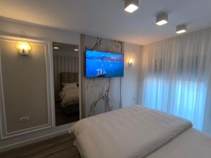 1 dormitorio con 1 cama y TV en la pared en Spa Tesla 2, en Batajnica