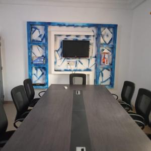 uma sala de conferências com uma grande mesa de madeira e cadeiras em Complexe M27 em Sali Nianiaral