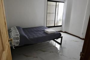 een klein bed in een kamer met een raam bij Blue Dreams Hotel in Hone Creek