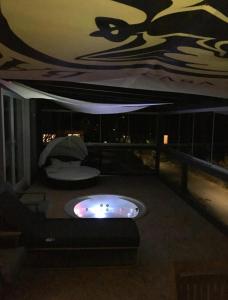 une chambre avec un bain à remous sur un balcon la nuit dans l'établissement Harmony&Apollo, à Adenau
