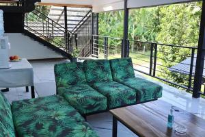 een groene bank op een balkon met een tafel bij Blue Dreams Hotel in Hone Creek