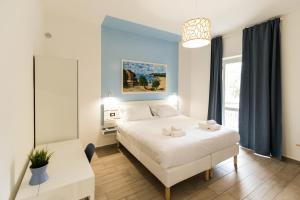 ein Schlafzimmer mit einem großen weißen Bett und einem Tisch in der Unterkunft Borgo Sant'Angelo Apartment in Rossano
