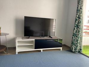 a living room with a flat screen tv on a white cabinet at Apartamento de 3 hab en Costa Adeje centro in Adeje