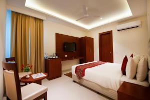 a hotel room with a bed and a television at Bonito Rooms- Home Stay in Ecotech-III in Greater Noida