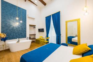 1 dormitorio con bañera, cama y espejo en L'Angolo d'o core, en Nápoles