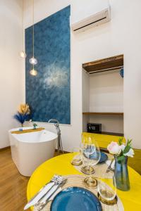 a dining room with a yellow table and a tub at L'Angolo d'o core in Naples