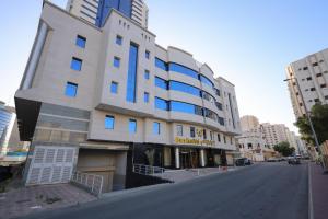 a white building with blue windows on a street at فندق البراق الماسي in Al Khansāk