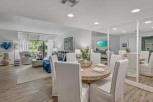 Un comedor y una sala de estar con mesa y sillas. en Beachwalk Villa 5125, en Destin