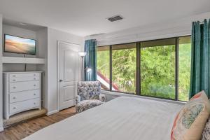 Un dormitorio con una cama y una silla y ventanas. en Beachwalk Villa 5125, en Destin 42 fotos más