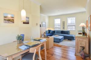 uma sala de estar com uma mesa e um sofá azul em NEW AC 1 Bedroom w Private Deck & Patio em Provincetown