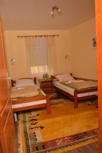 a bedroom with two beds and a window at Etno Kuca Paor-apartmani in Kikinda