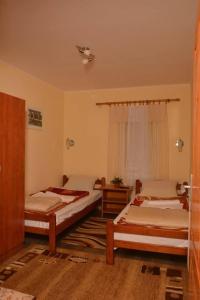 a bedroom with two beds and a window at Etno Kuca Paor-apartmani in Kikinda