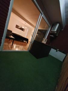 a view of a room with a piano and a green floor at Albufera Rooms in Valencia