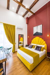 sypialnia z żółtą i czerwoną ścianą w obiekcie L'Angolo d'o core w mieście Napoli