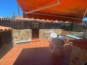 a patio with a table and chairs and a fence at Santa Fe Bunglow Deluxe Playa Del Ingles in Maspalomas