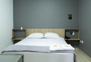 a bedroom with a large bed with two towels on it at Hotel Ruiseñor Itagui in Itagüí