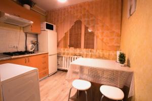 a kitchen with a table and chairs in a room at Nadezhda Apartments at Kabanbay Batyr 79 in Almaty
