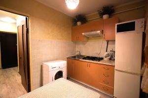 uma pequena cozinha com uma máquina de lavar roupa e uma máquina de lavar roupa em Nadezhda Apartments at Kabanbay Batyr 79 em Almaty