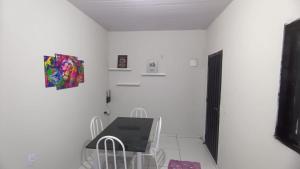 um quarto branco com uma mesa e cadeiras e uma televisão em Cozy em Palmas