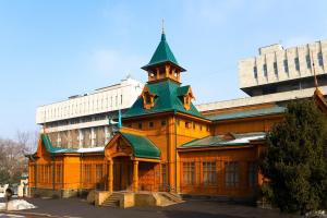 ein Gebäude mit einem Turm darüber in der Unterkunft Nadezhda Apartments at Kabanbay Batyr 79 in Almaty