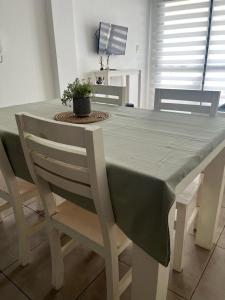 una mesa de comedor con un mantel verde. en Alameda Departamento Temporario en Santa Fe