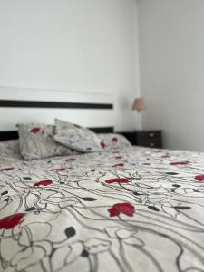 Una cama con flores rojas en un dormitorio en Alameda Departamento Temporario en Santa Fe