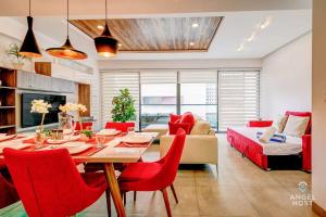 a living room with a dining table and red chairs at Condo with Amenities Sleeps 8 Roof Pool Gym in Playa del Carmen