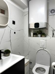 Baño blanco con aseo y lavamanos en Tarino Apartment en Split