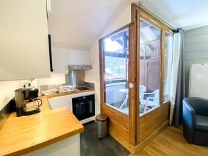 a small kitchen with a glass door with a balcony at 3- Charmant studio Brides-les-Bains in Brides-les-Bains