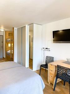 a bedroom with a bed and a desk and a tv at 3- Charmant studio Brides-les-Bains in Brides-les-Bains