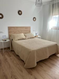 Habitación blanca con cama grande y suelo de madera. en Bajo casa en Moaña, en Moaña