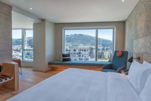 GO Quito Hotel في كيتو: غرفة نوم بسرير ونافذة كبيرة