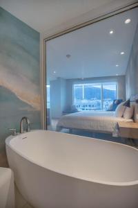 uma banheira numa casa de banho com um quarto em GO Quito Hotel em Quito